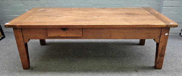 A French provincial cherry wood farmhouse table, 19th century, reduced in height, the cleated three plank top above a frieze drawer on square tapered