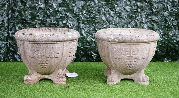 A pair of reconstituted stone circular jardinieres, with grape and vine moulded bodies on lion's paw feet, 60cm diameter x 49cm high, (2).