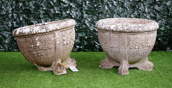 A pair of reconstituted stone circular jardinieres, with grape and vine moulded bodies on lion's paw feet, 60cm diameter x 49cm high, (2), (a.f).