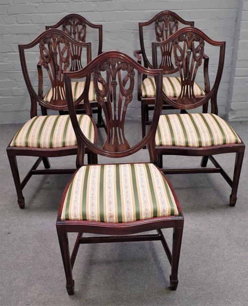 A set of twelve George III style shield back mahogany dining chairs on tapering square supports, to include a pair of carvers (12).