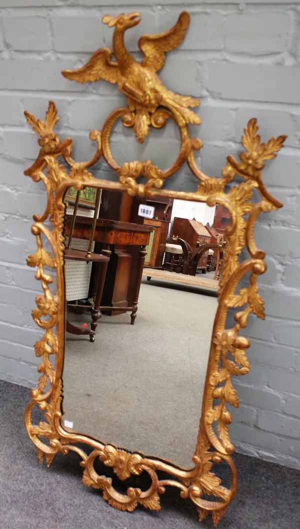 A Chippendale style upright wall mirror, the giltwood frame carved with flowers, leaves, and 'C' scrolls, surmounted by a ho-ho bird, 116cm high x 56c