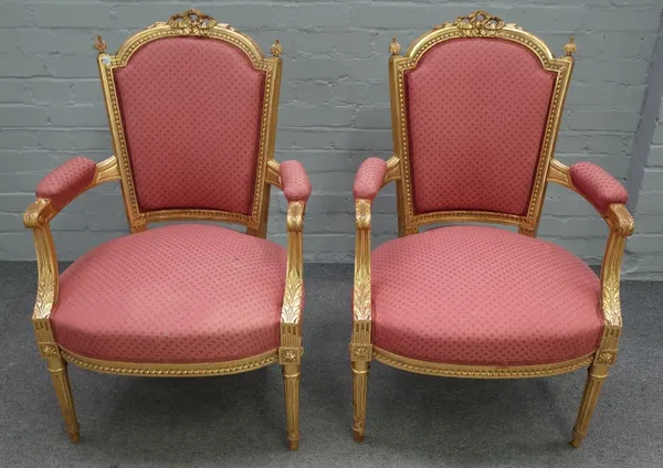 A pair of Louis XVI style gilt framed open armchairs with ribbon tied crest and bow seat on fluted supports, 63cm wide x 95cm high (2).