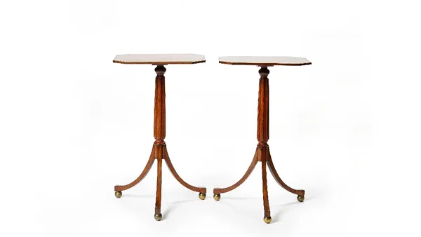 A pair of Regency brass bound mahogany tripod occasional tables, with compressed octagonal tops on reeded columns and three downswept supports, 43cm w