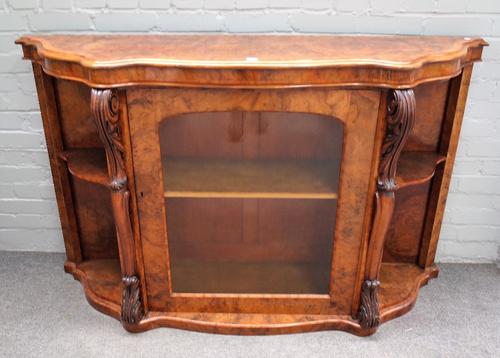 A Victorian figured walnut serpentine credenza, with central frieze cupboard flanked by open shelves, 160cm wide x 99cm high.