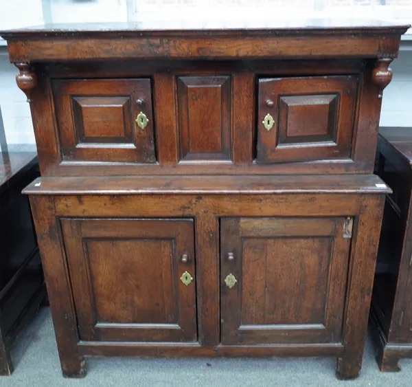 A 17th century oak court cupboard, with two pairs of raised panel doors on stile feet, 126cm wide x 136cm high.