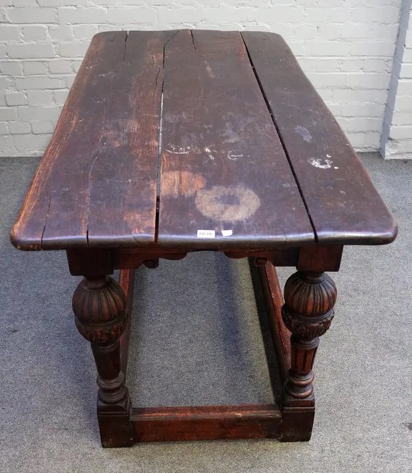 A 17th century and later oak refectory table, the triple plank top on cup and cover supports, united by a perimeter stretcher, 75cm wide x 168cm long.