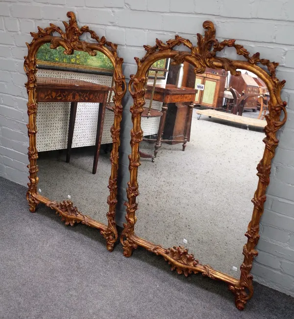 A pair of mid-19th century gilt framed arch top mirrors, with foliate chased frames, 71cm wide x 123cm high.