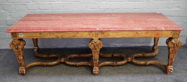 An Italian giltwood window stool, in late 17th century style, 19th century, on six scrolled foliate and cabochon carved tapering square legs united by