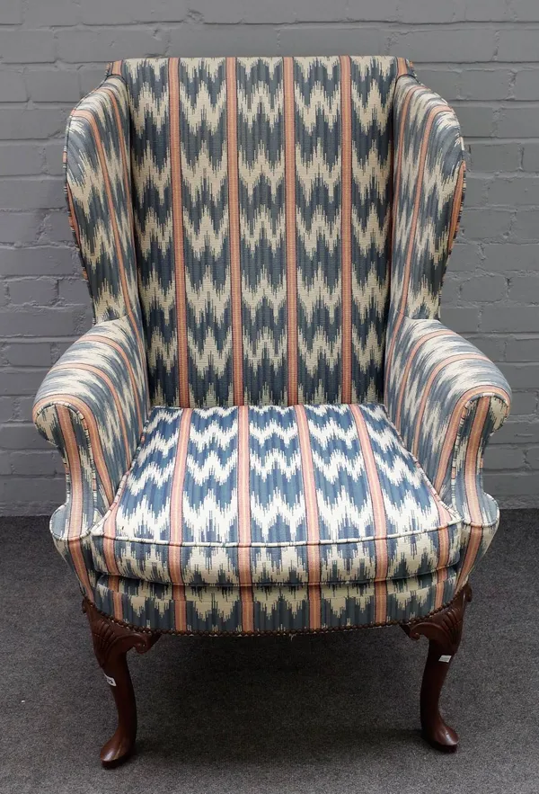 A George I style wingback armchair on shell capped supports and pad feet, 80cm wide x 117cm high.