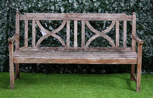 A teak garden bench with double X-framed back and slatted seat, 151cm wide x 86cm high.