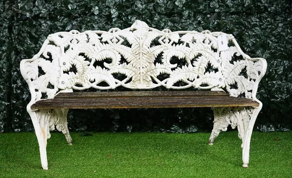 After Coalbrookdale; a fern and berry pattern garden bench, with white painted cast iron with teak slats, 85cm high x 142cm wide.