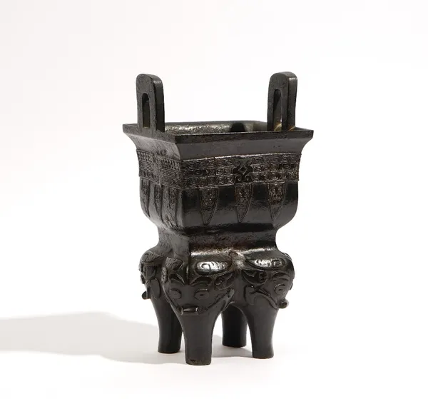 A Chinese archaistic bronze vessel, probably Qing dynasty, the rectangular body cast with a band of leiwen above stiff leaves, the tops of the four bu