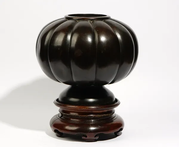 A large bronze vase, probably Japanese, late 19th/20th century, of melon form raised on a circular spreading base, 29.5cm. high, wood stand.