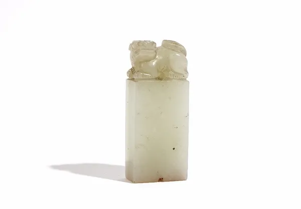 A Chinese pale celadon jade seal, Qing Dynasty, surmounted by a Buddist lion, 6.5cm. high.