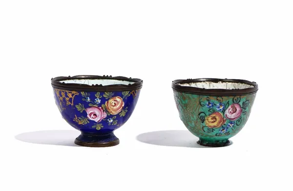 Two small enamelled cups, probably Turkish, 19th century, each painted with roses and forget-me-nots within gilt frames against a blue or green ground