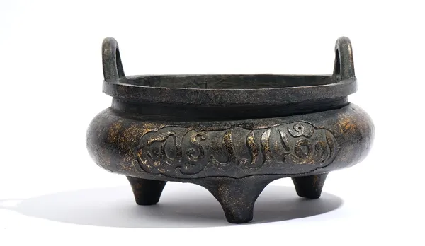 A large Chinese Islamic market bronze tripod censer, six character Xuande mark but later, with two shaped panels in relief reserved with inscriptions,