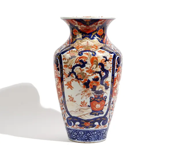 A tall Japanese Imari vase, Meiji period, painted with two large panels of vases of flowers and pomegranates, separated by smaller panels of birds and