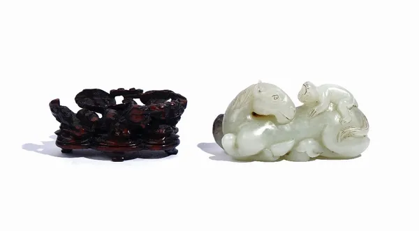 A Chinese jade group, Qing dynasty, carved as a monkey seated on the back of a recumbent horse, the stone of pale celadon tone with black and russet i