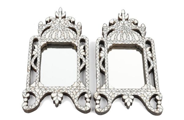 A pair of small Ottoman style mother-of- pearl mounted mirrors, 20th century, of pierced shaped rectangular form, 38cm high x 19.5cm wide. (2)