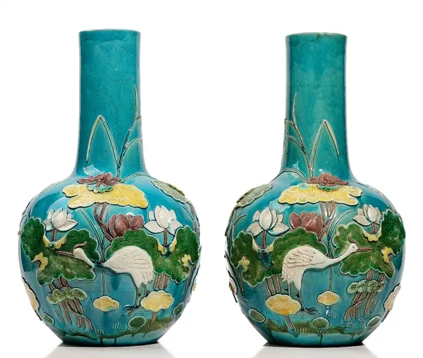 A large pair of Chinese turquoise- ground bottle vases, early 20th century, in the style of Wang Binrong, each moulded and coloured with a crane among