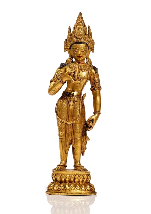 A Sino Tibetan gilt bronze figure of Vajrapani, standing holding a vajra in the right hand and a ghanta in the left, raised on a double lotus base, 26