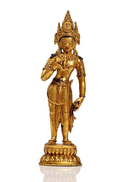 A Sino Tibetan gilt bronze figure of Vajrapani, standing holding a vajra in the right hand and a ghanta in the left, raised on a double lotus base, 26