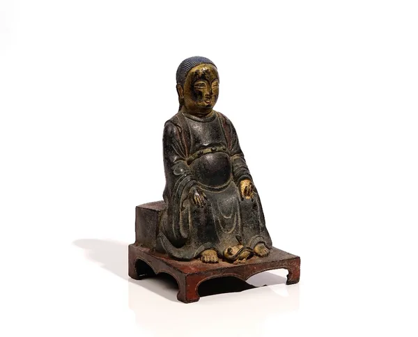 A Chinese Ming style bronze figure of Zhenwu, the deity seated with a snake and tortoise at his feet, partly gilt and coloured, 25cm. high.