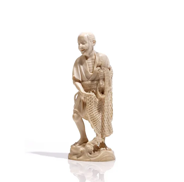 A Japanese ivory okimono of a fisherman, Meiji period, carved standing on rocks holding a net, unsigned, 15.5cm. high.Weight 212 gms.