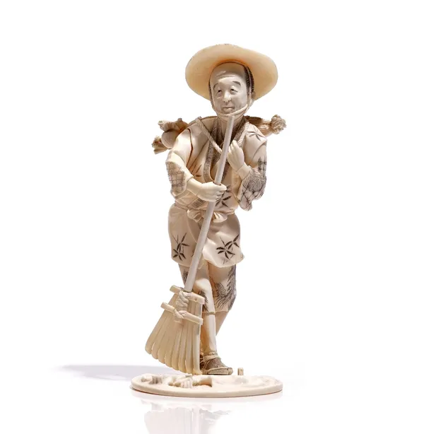 A Japanese ivory okimono of a man, Meiji/Taisho period, carved standing with a bundle of wood across his back and holding a broom in his right hand, s