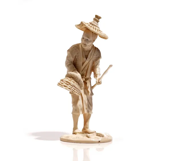 A Japanese ivory okimono of a fisherman, Meiji / Taisho period, carved standing holding a basket and stick, signed, 18.5cm. high.Weight 252 gms.