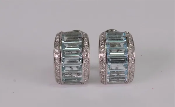 A pair of precious white metal, aquamarine and diamond set earclips of half hoop design, channel set with baguette cut aquamarines, between two rows o