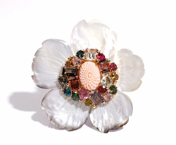 A carved coral, diamond and varicoloured gemstone set brooch, of flowerhead design, mounted on carved mother-of-pearl petals and with a yellow preciou