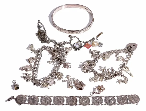 A silver curb link charm bracelet, fitted with eleven charms, including a crocodile, a horse and a key, on a silver heart shaped padlock clasp, a silv