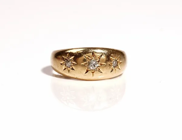 An 18ct gold and diamond set three stone ring, star gypsy set with a row of cushion shaped diamonds, Birmingham 1908, ring size K, gross weight 5.4 gm