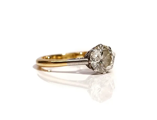 An 18ct gold ring, claw set with a circular cut diamond between platinum shoulders, ring size I and a half, (note: sizing beads), gross weight 3.1 gms