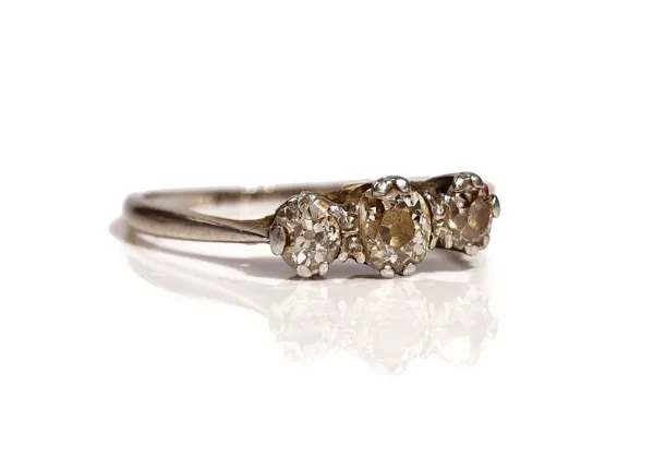 A platinum and diamond set three stone ring, mounted with a row of cushion shaped diamonds and with the principle diamond mounted at the centre, detai