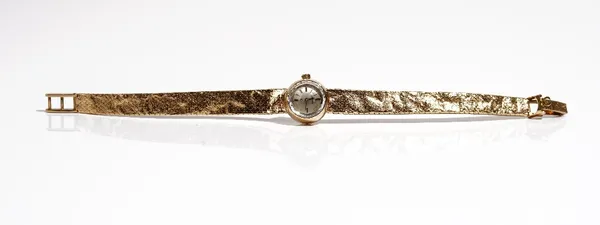 An Omega 9ct gold lady's bracelet wristwatch, the signed silvered dial with baton shaped numerals, on a tapering 9ct gold bracelet, having a textured