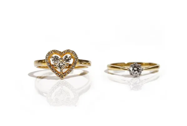 A gold and diamond set heart shaped cluster ring, mounted with a princess cut diamond, two principal circular cut diamonds and with an outer openwork