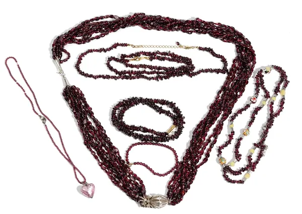 A seven row necklace of garnet beads, on a hook shaped clasp, a garnet bead necklace with a heart shaped drop, four single row garnet bead necklaces a