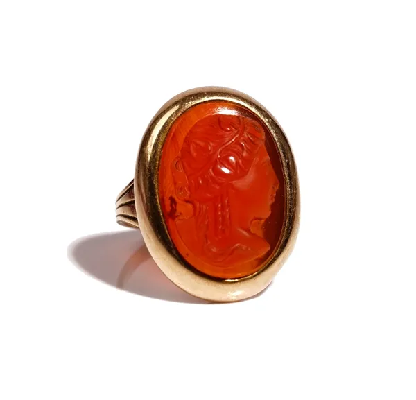 A gold and oval cornelian cameo ring, carved as the portrait of a classical lady, between ridged shoulders, ring size L, gross weight 5.6 gms.