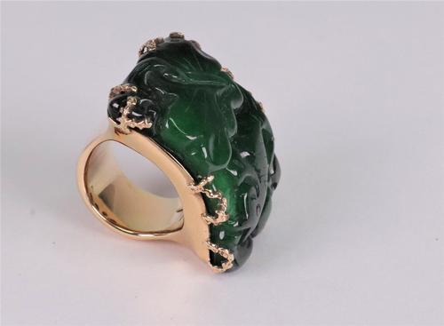 Carved jadeite dress ring of arched plaque design, the rectangular jadeite plaque carved with carp, claw set to a yellow precious mount, ring size M/N