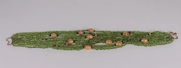 A cabochon peridot and gilt metal bead multi-strand necklace, suspended from an openwork gold clasp, set with a peridot.