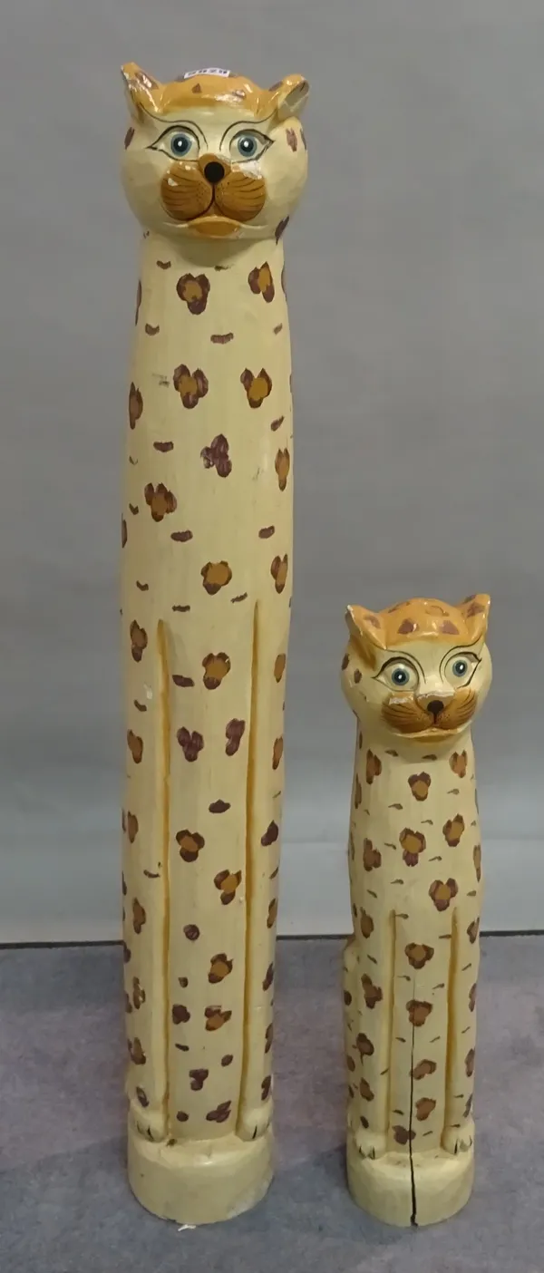 A pair of modern tall carved wooden models of leopards, the tallest 104cm tall.