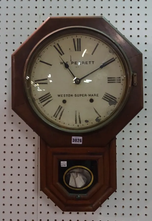 W. E. Perrett, Weston-Super-Mare, an oak cased wall clock with key and pendulum, 40cm wide x 60cm high.