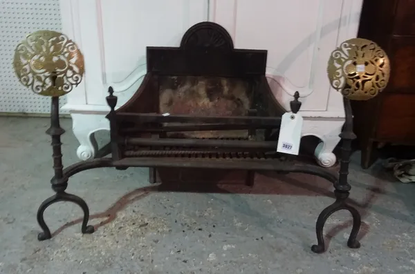 An early 20th century fire basket with brass circular fret cut fire dogs, 85cm wide x 60cm high.