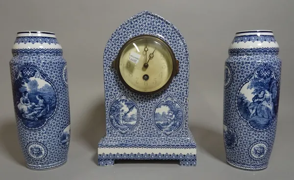 A 20th century blue and white ceramic clock garniture with a pair of cylindrical vases 27cm high (3).