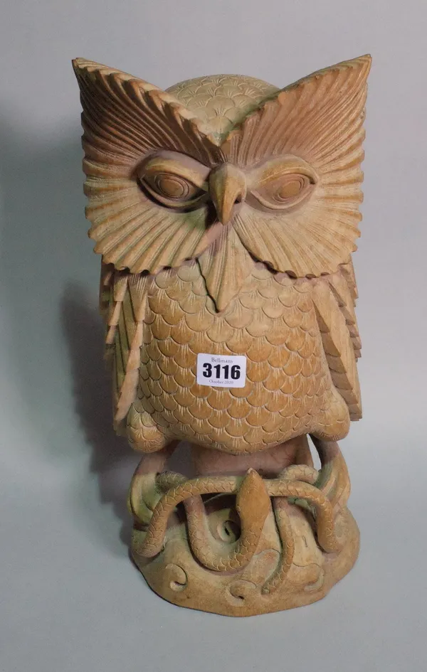 A 20th century carved hardwood large figure of an owl upon a snake, 46cm tall.