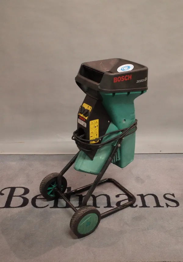 A Bosch AXT 2000 HP garden shredder and a garden hose on trolly.