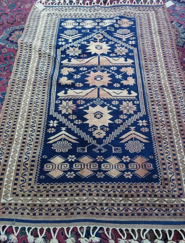 A Yagabedir prayer style Turkish rug, the dark indigo mehrab with stylised madder flowerheads, various minor borders, washed 174cm x 120cm.