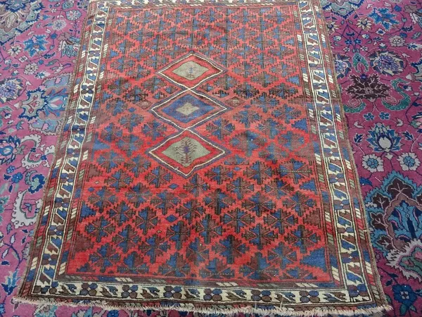 A Beshir rug, madder field with three diamonds, with flower heads, 130cm x 105cm.